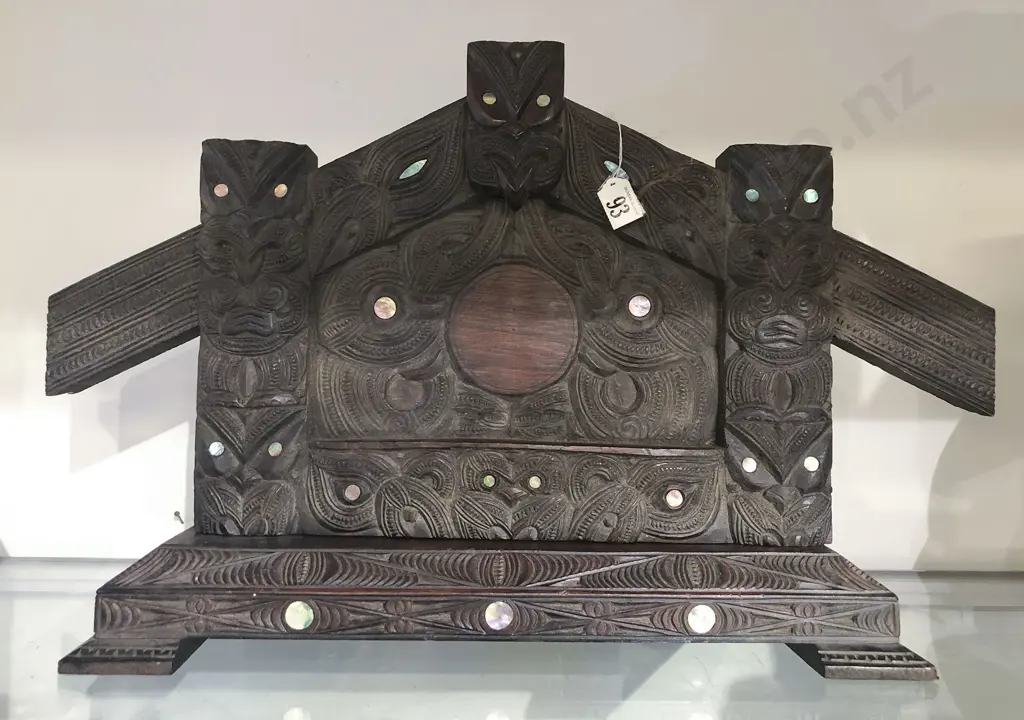 A Ngati Tarawhai photo frame. Carved in the form of a wharenui entrance. The amo with ancestral figures with inset paua shell eyes Image 1++