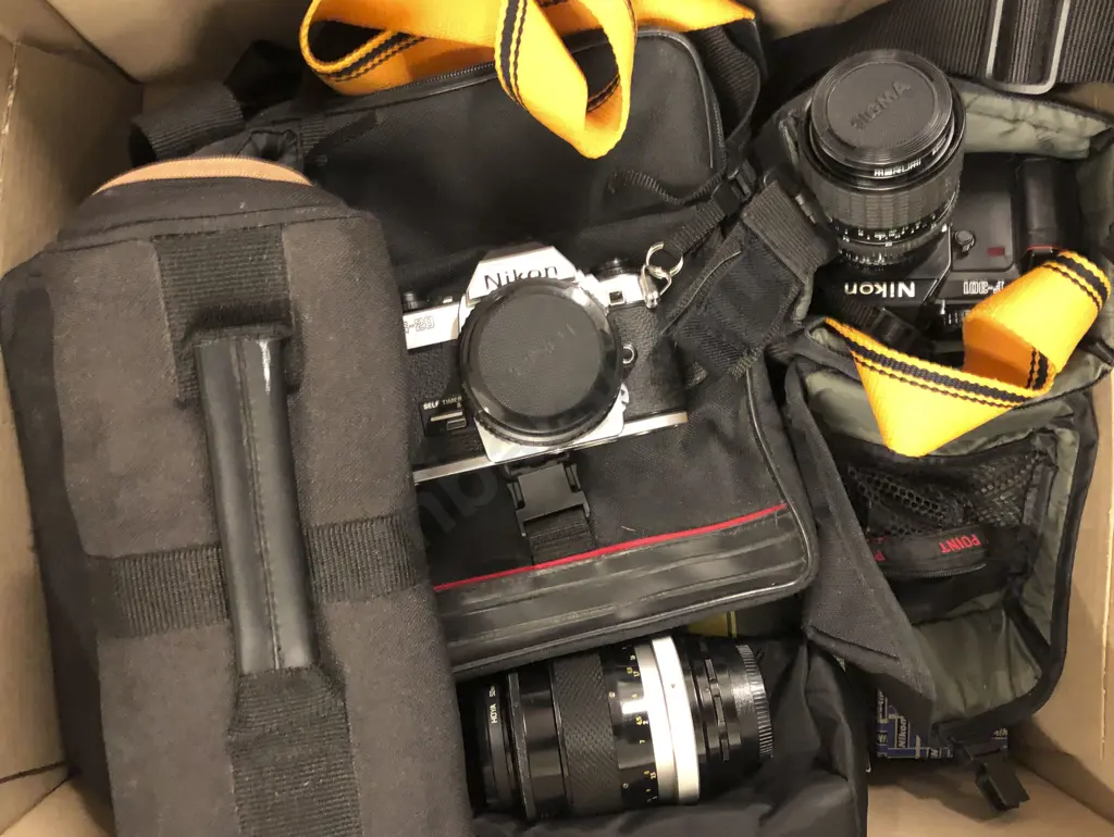 Two Nikon Cameras Together With Assorted Lenses and Cases Image 1++