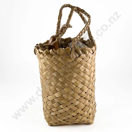 Gourd with carved decoration in a woven muka basket