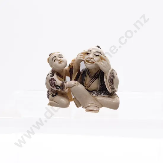 Signed and Stained Ivory Netsuke of a Grandfather Playing with His Grandson