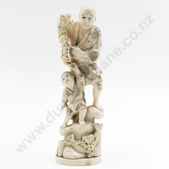 Japanese Signed Carved Ivory Figure of a Standing Man Gathering Grapes