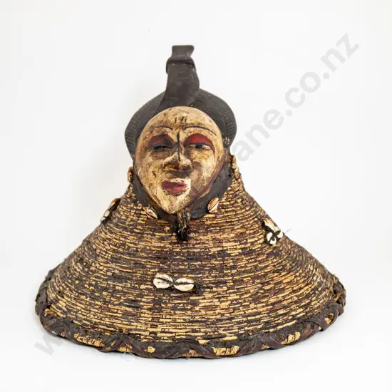 A Decorative African Mask Surmounting Painted Basketry With Cowrie Shells