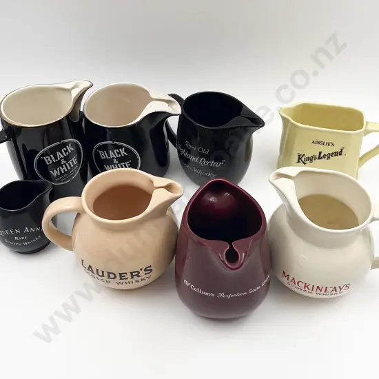 Eight Assorted Whisky Advertising Jugs