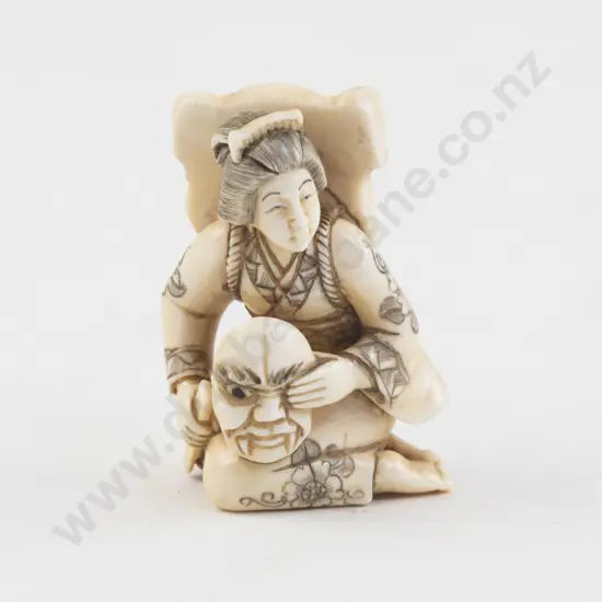 Signed Ivory Netsuke of a Kneeling Woman Painting Demon Masks